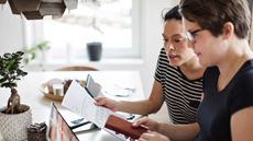 Couple at a table working on their taxes on a laptop