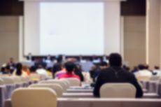 Blurry of auditorium for shareholders' meeting or seminar event with projector.