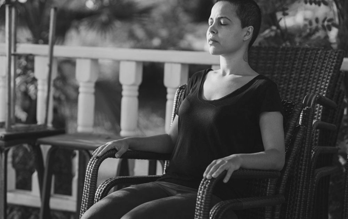 Woman in black top, sitting in chair meditating